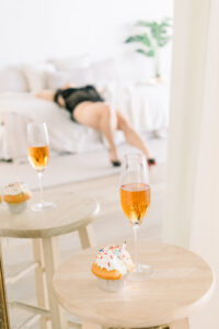 Orange County Birthday Ideas for Adults. A Boudoir birthday photoshoot with Rose, a cupcake, and woman blurred out on the bed in the background.