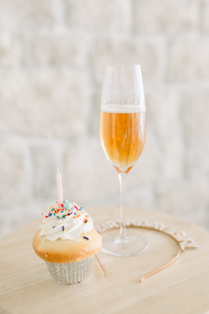 Wine glass and birthday cupcake styled for a birthday boudoir photography session.