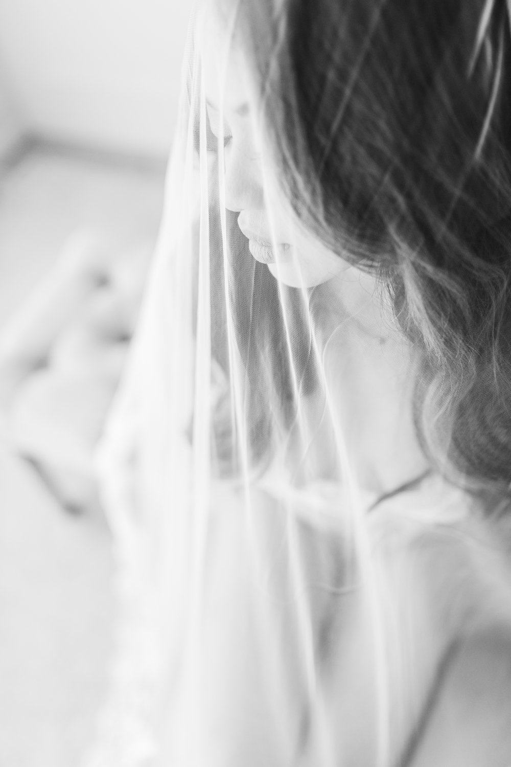 bridal boudoir timeline, a woman wearing a bridal ensemble and looking confidently into the mirror during an elegant bridal boudoir session.