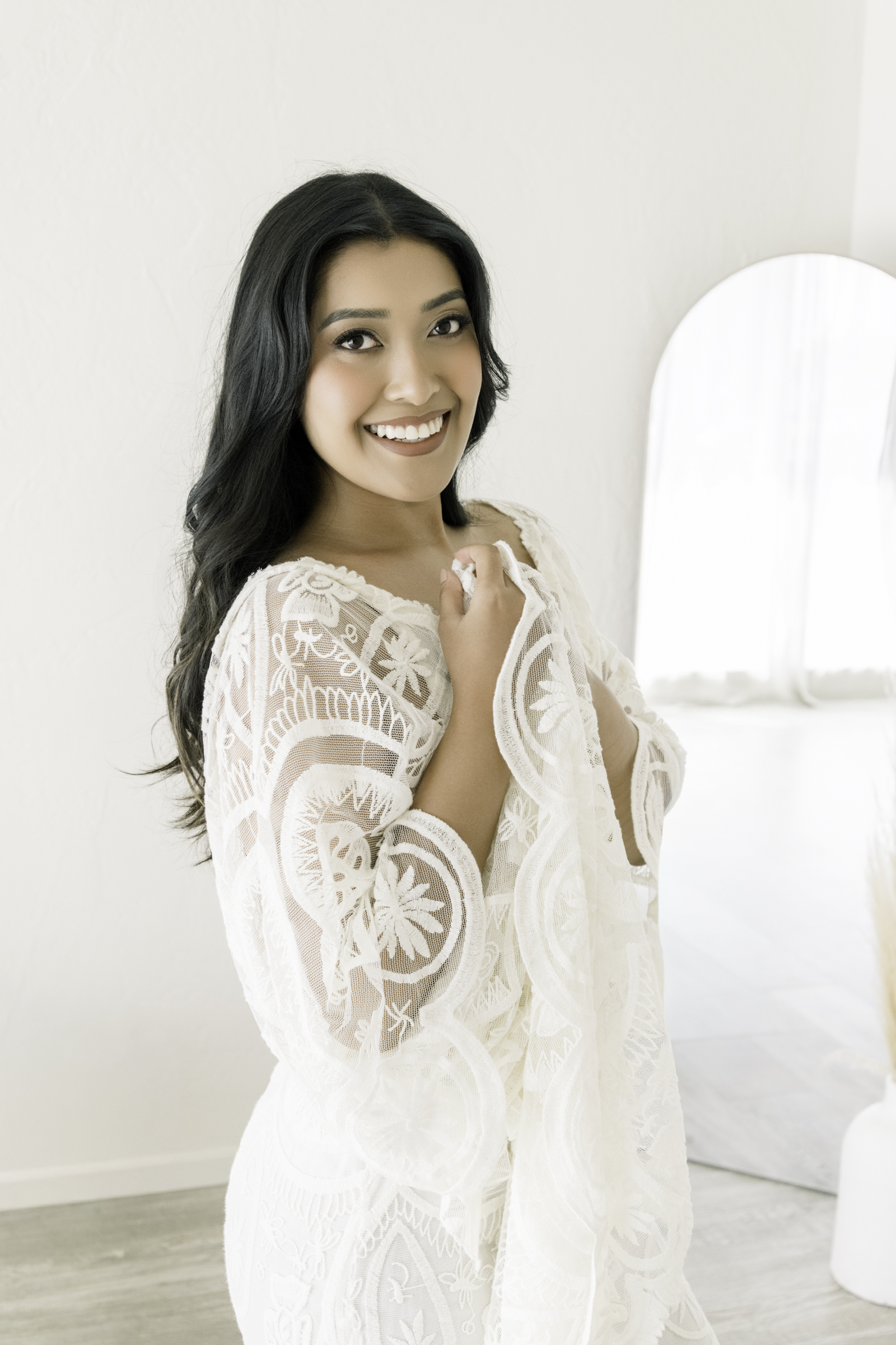 Boudoir photography worth it: confident woman smiling during an empowering boudoir session celebrating self-love and beauty.