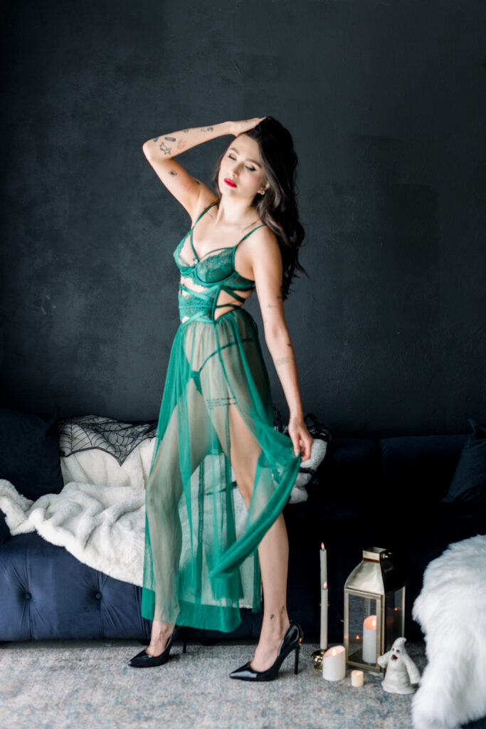 Sheer emerald gown at a Halloween boudoir session in Orange County against a black textured wall 